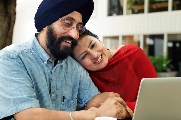 2 people cuddling in front of laptop