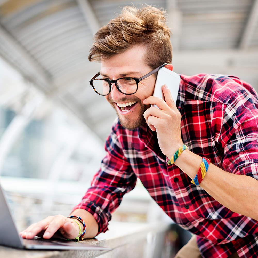 laughing man in plaid shirt on phone