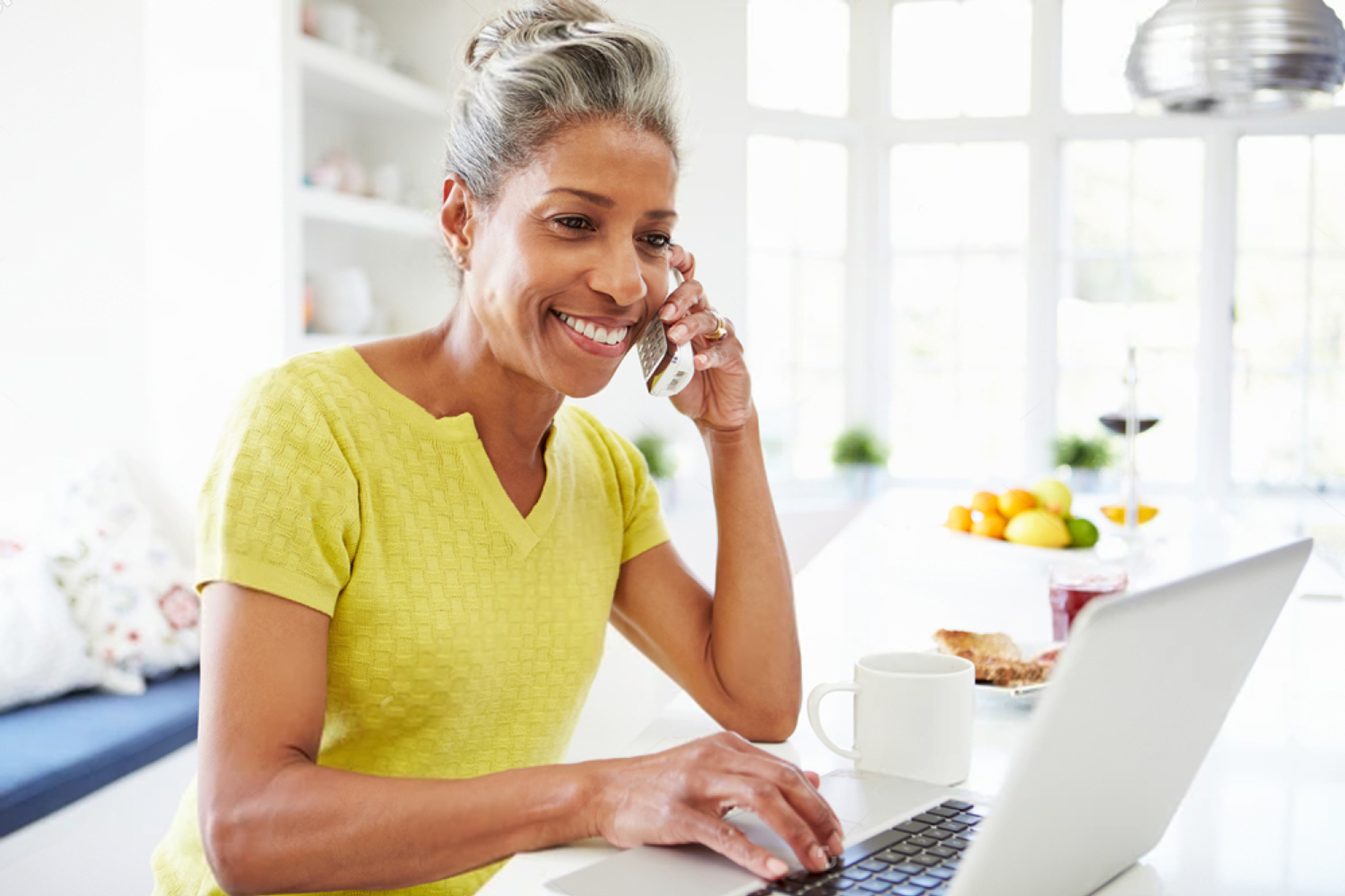 woman on phone with laptop
